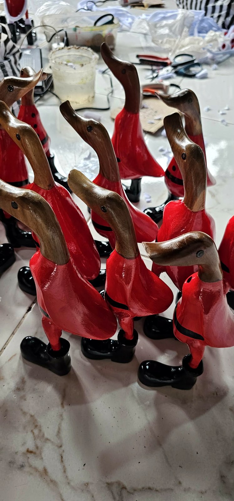 Mehrere stehende Weihnachtsmann-Enten warten in Reihe auf Accessoires und Bemalung